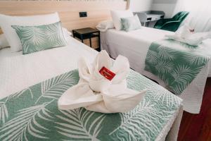 2 camas con toallas blancas encima en PENSIÓN CALDEA, en Caldas de Reis