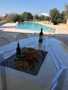 uma mesa com um prato de comida e uma garrafa de vinho em Villa Alice em Casarano