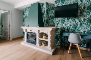 sala de estar con chimenea y TV en la pared en PENSIÓN CALDEA, en Caldas de Reis
