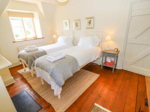 a bedroom with two beds with white sheets and a window at No 1 Eastington in Cheltenham