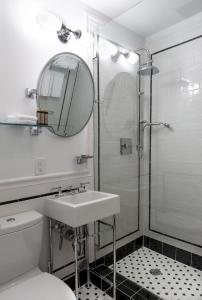 Baño blanco con lavabo y espejo en Shepley South Beach Hotel en Miami Beach