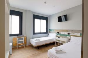 Kleines Zimmer mit 2 Betten und einem TV in der Unterkunft Hey Rooms in Cerdanyola del Valles
