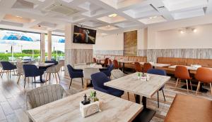 a restaurant with tables and chairs and a tv on the wall at Neptun in Pomorie