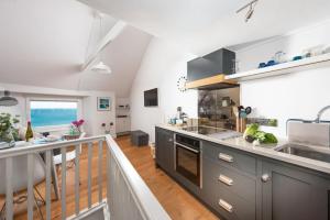 a kitchen with gray cabinets and a balcony at Nutshell, Marazion in Marazion