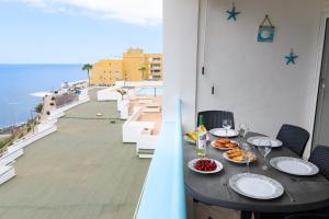 una mesa con comida en el balcón con vistas al océano en Blue Horizon en Callao Salvaje