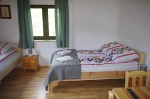 Liszna的住宿－Kyczyrka，卧室配有带枕头的床铺和窗户。