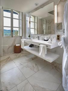 La salle de bains est pourvue d'un lavabo et d'un grand miroir. dans l'établissement Château de Longpré, à Varilhes