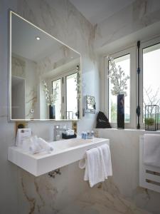 La salle de bains blanche est pourvue d'un lavabo et d'un miroir. dans l'établissement Château de Longpré, à Varilhes
