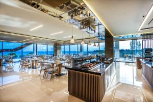 a restaurant with tables and chairs and windows at Ammoa Luxury Hotel & Spa Resort in Nikiti