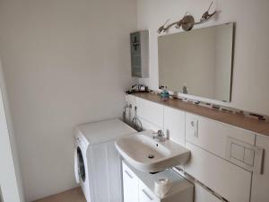 a white bathroom with a sink and a mirror at Unterkunft Mau in Rotenburg an der Wümme