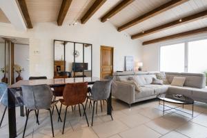 a living room with a table and a couch at "MORANDE" grande maison avec Piscine Chauffée in La Noue