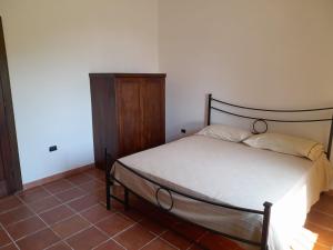 1 dormitorio con 1 cama y armario de madera en Villa Mattia en Montegiordano