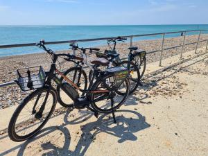 dwa rowery zaparkowane obok ogrodzenia na plaży w obiekcie Seaside Holiday Home Inside a Resort w mieście Selsey