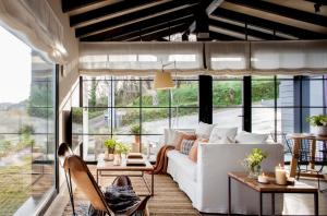 a living room with a white couch and large windows at La Guarida Lugás cabañas de lujo in Villaviciosa