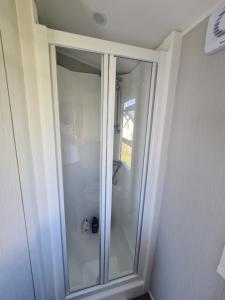 a glass shower in a bathroom with at Seaside Holiday Home Inside a Resort in Selsey +27 photos