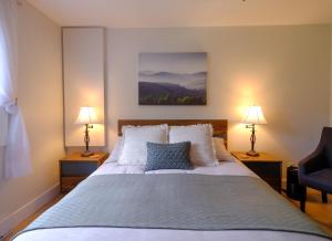 a bedroom with a large bed with two lamps at Le Pimbina in Mont-Tremblant