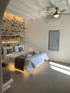 a bedroom with two beds and a brick wall at Thomas Villas on the beach Katapola in Katapola