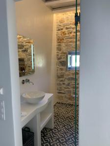 La salle de bains est pourvue d'un lavabo et d'une douche. dans l'établissement Thomas Villas on the beach Katapola, à Katápola