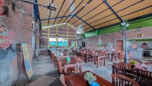 un ristorante con tavoli e sedie e un muro di mattoni di Hotel Shinta 1 near Stasiun Kertosono Mitra RedDoorz a Pelem