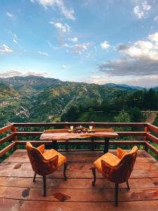 una mesa y sillas en una terraza con vistas en ZirvedeKal Suit Otel en Çamlıhemşin