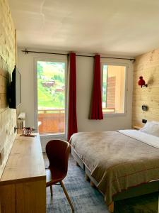 a bedroom with a bed and a large window at Hotel Lac Bleu 1650 in Saint-François-Longchamp