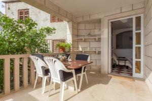 a patio with a wooden table and chairs on a balcony at Holiday Home in Komarna
