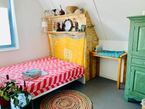 een kleine kamer met een bed en een tafel bij Canal House - Homestay in Alkmaar