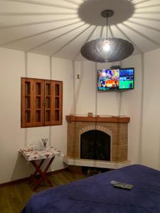 sala de estar con TV y chimenea en Villa de Chino en Monte Verde