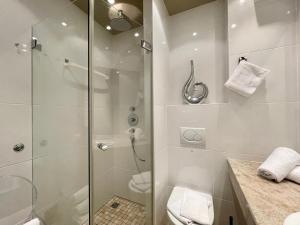 uma casa de banho branca com um chuveiro e um WC. em Lieblingsplatz No 2 em Kampen