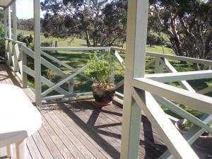 a porch with a potted plant on a white fence at Wenton Farm Holiday Cottages in Middleton