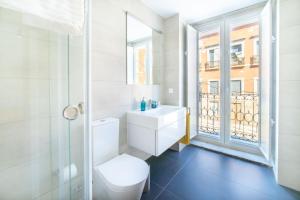 La salle de bains blanche est pourvue de toilettes et d'une fenêtre. dans l'établissement Blue by the River 1 - elegant two-bedroom in Santos, à Lisbonne