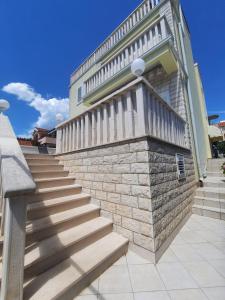 a building with stairs on the side of it at Apartmani Anita in Brodarica