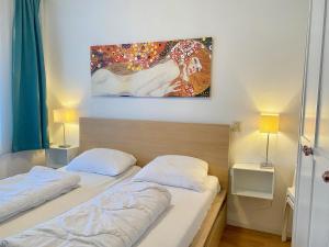 two beds in a bedroom with a painting on the wall at Badhotel 316 in Callantsoog