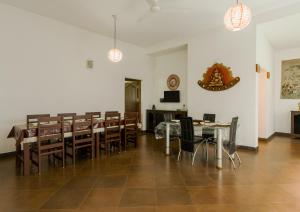 維提里的住宿－SaffronStays WellBeingVilla, Wayanad，一间带桌椅和电视的用餐室
