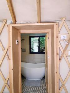 a bathroom with a bath tub and a window at Love Frequency - יורט קסום במתת in Mattat