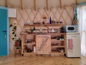 a kitchen with a wooden cabinet and a refrigerator at Love Frequency - יורט קסום במתת in Mattat +63 photos