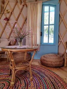 um quarto com uma mesa, uma janela e um tapete em Love Frequency - יורט קסום במתת em Mattat