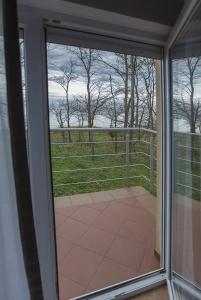 a sliding glass door with a view of a field at Villa Vip in Trzęsacz