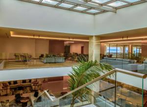 a large lobby with tables and chairs in a building at Ammoa Luxury Hotel & Spa Resort in Nikiti