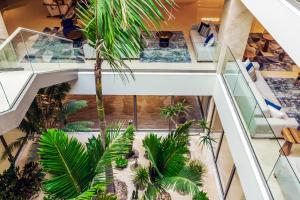 an indoor garden in a building with palm trees at Ammoa Luxury Hotel & Spa Resort in Nikiti