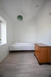 Un dormitorio con una cama y una cómoda de madera. en Stadium / Central / Park / Art Gallery, en Tórshavn