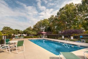a swimming pool with chairs and a table next to at Anchorage Inn Rochester in Rochester