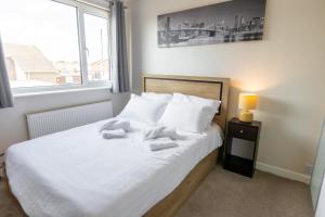 una camera da letto con un letto e due asciugamani di Hullidays East Modern Detached 3 Bed House a Hull