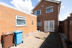 a brick house with a trash can in front of it at Hullidays East Modern Detached 3 Bed House in Hull