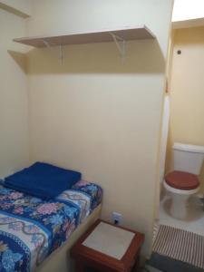 a small room with a bed and a toilet at Hostel Colonial hospedagem domiciliar in Rio de Janeiro