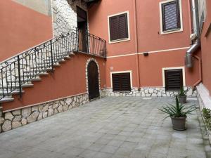 a building with a staircase next to a courtyard at B&B Alessia in San Cataldo