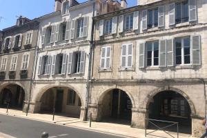 an old stone building with arches on a street at terrasse centre ville in La Rochelle