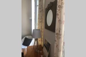 a bedroom with a bed and a mirror and a lamp at terrasse centre ville in La Rochelle