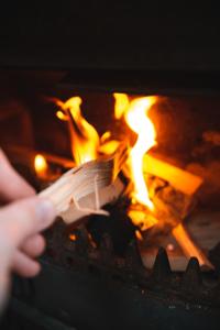 a person holding a fork in front of a fire at Sunbank Yurt in Llangollen