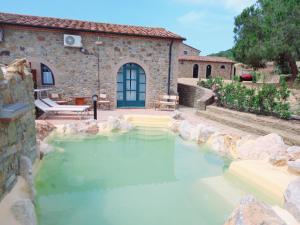 a pool of water in front of a house at Agriturismo La Fontanella & Glamping in Suvereto